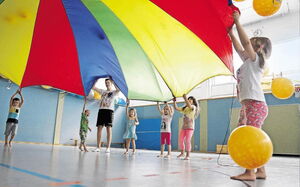 Foto: Alexander Heimann. Mit dem Tuch versetzen die Kinder der Büttelborn Kita Am Grünen Weg in der Halle des Turnvereins Bälle in Bewegung. Einmal in der Woche kommen sie in die Turnhalle, um unter fachkundiger Anleitung ihre Motorik zu schulen.